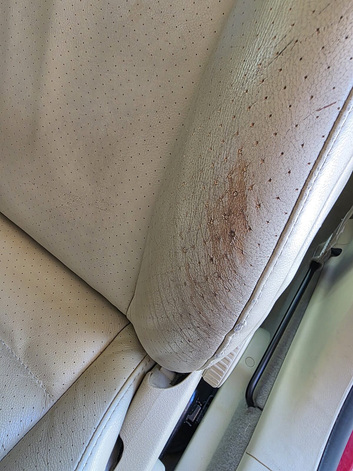 Worn leather armrest before restoration